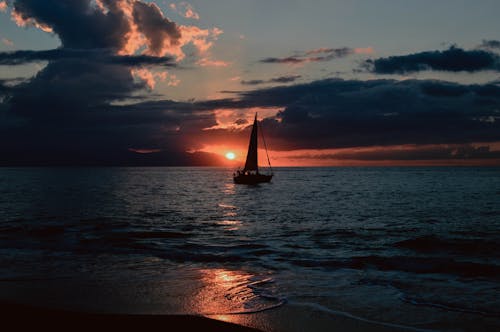 Kostenlos Schattenbild Des Segelboots Auf Dem Gewässer Während Des Sonnenuntergangs Stock-Foto