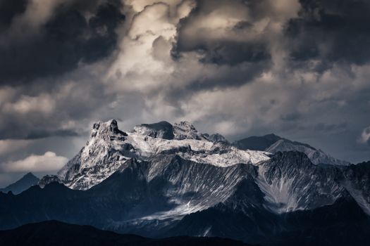 A striking view of Austria's snowy mountains under a dramatic cloudy sky.