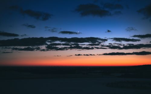 Free Captivating twilight scene in Poland with a crescent moon and colorful sky. Stock Photo