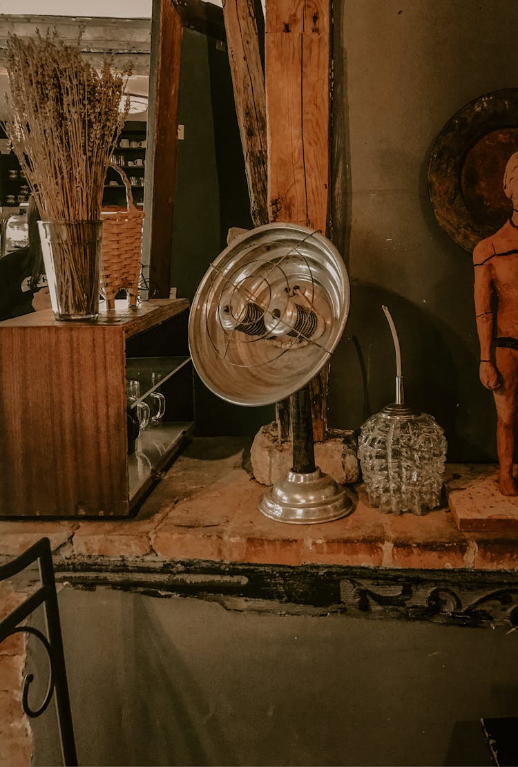 Vintage Metal Heater Placed On Shelf In Shop With Antiques