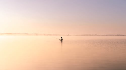 A Silhouette of a Person Fishing 