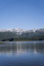 Body of Water Near Snowcapped Mountain Under Clear Blue Sky
