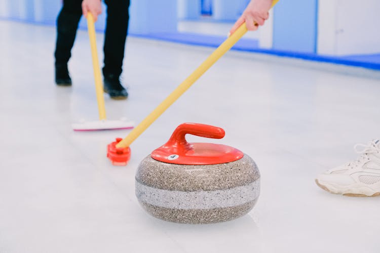 Players Brushing Ice While Playing Curling