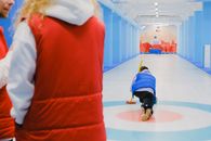 Sportive team playing curling during competition on ice rink