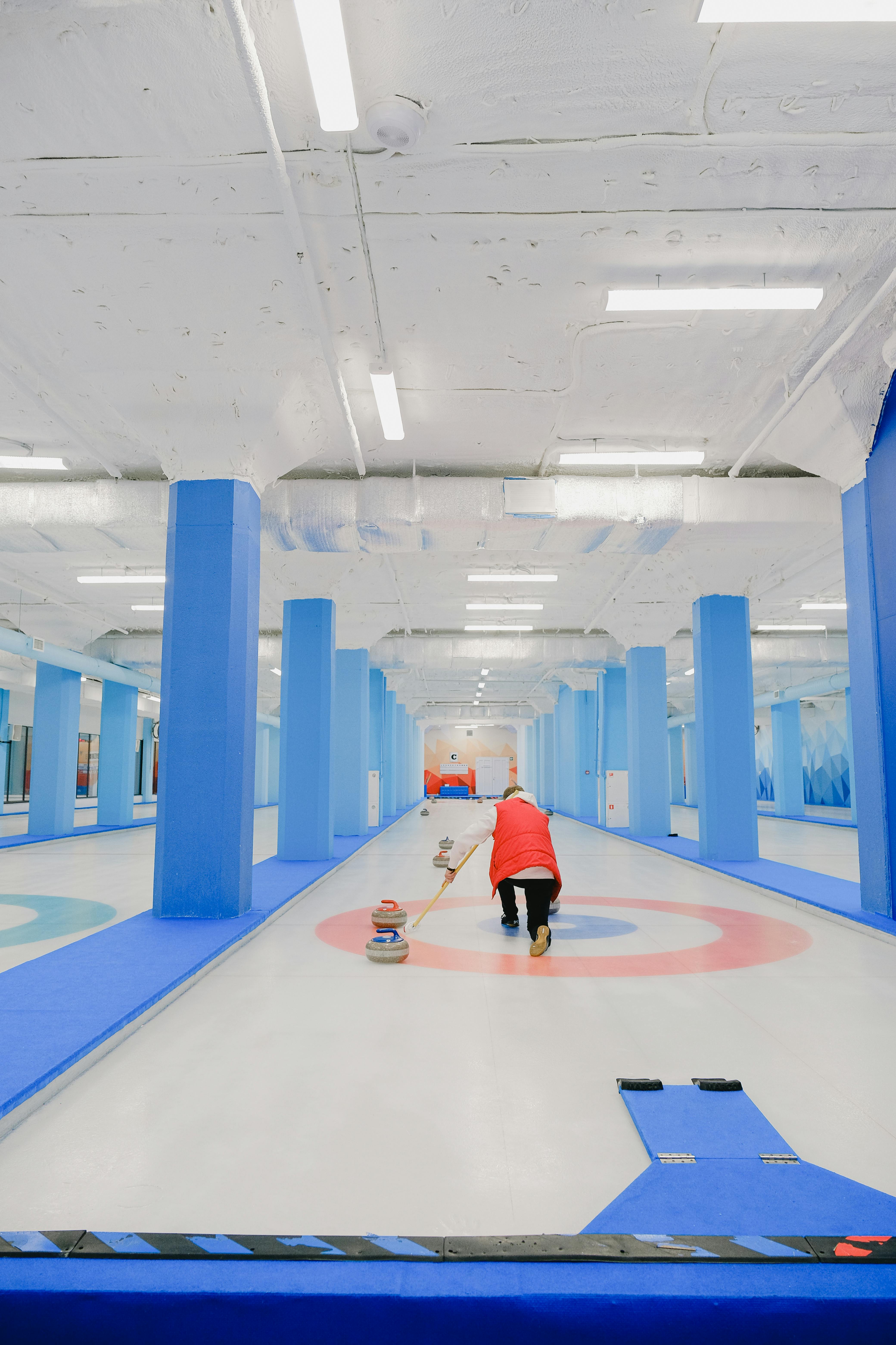 sportive person delivering stone to house while playing curling