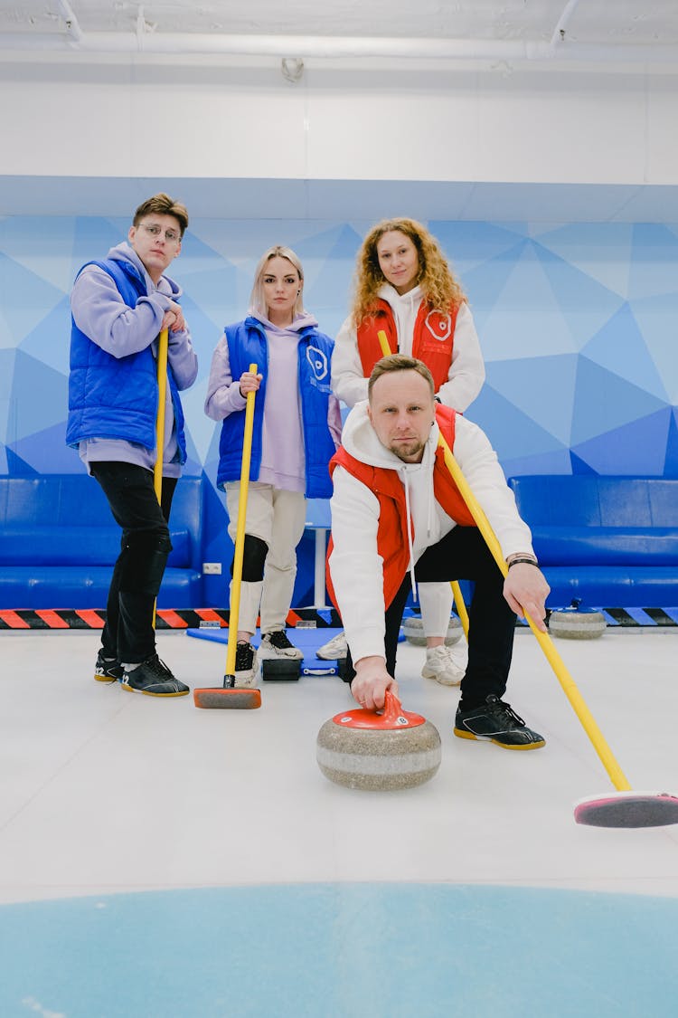 Curling Team With Equipment On Ice