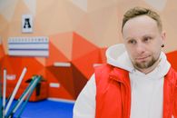 Serious male curling player in sportswear looking away with pensive face while standing near brooms and score board during game