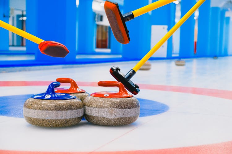 Curling Stones And Brooms In House