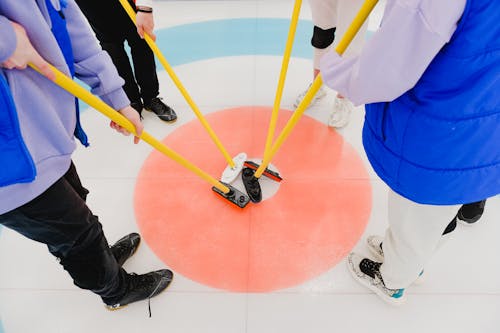 Free Crop curlers connecting brooms on floor Stock Photo