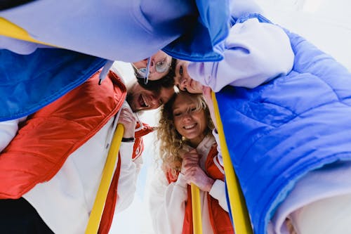 Low angle of cheerful curling team supporting each other in embrace during game