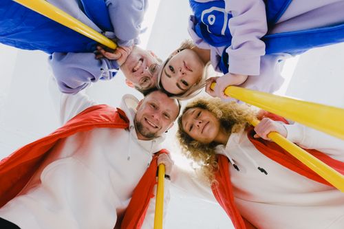 Free From below of happy group of curlers smiling and looking down while hugging each other Stock Photo