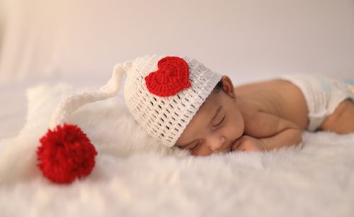Free Close-up of a peaceful sleeping baby wearing a cozy crochet hat with heart design. Stock Photo