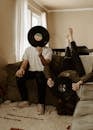 Man and Woman Holding Vinyl Records Against Faces