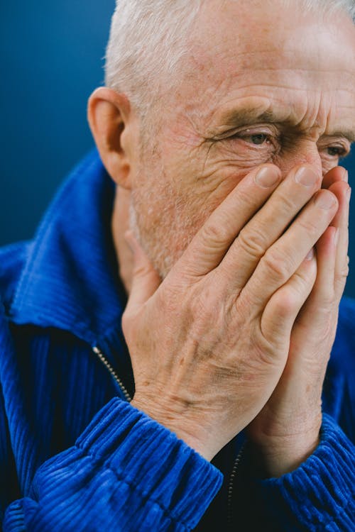 Senior man covering mouth with hands