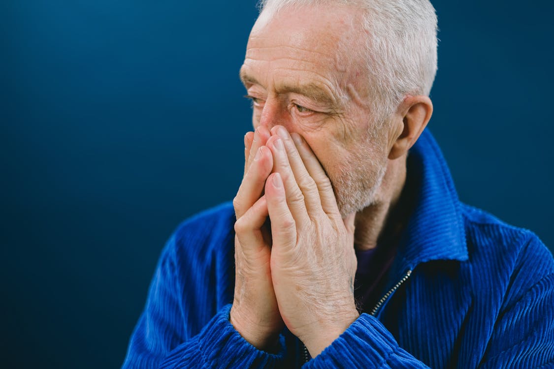 Free Stressed elderly man covering mouth Stock Photo