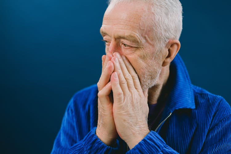 Stressed Elderly Man Covering Mouth