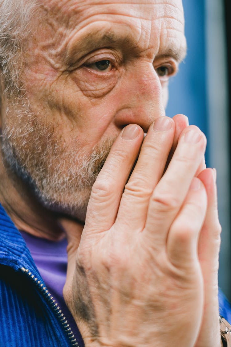 Man With Hands Covering Mouth