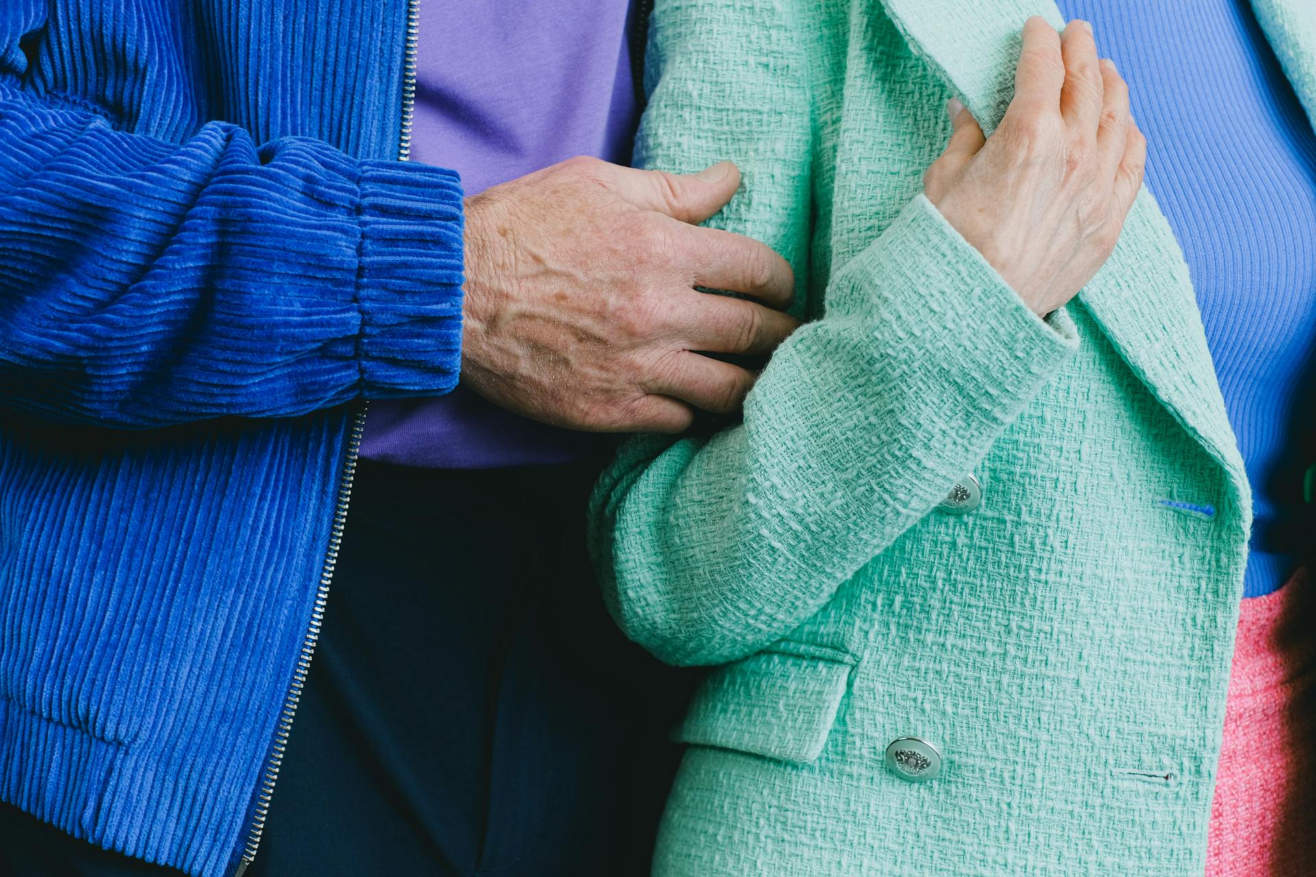 Close-up of senior adults in colorful blazers, showcasing fashion and connection.