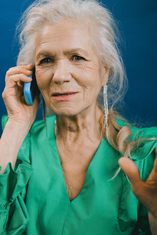 Elderly Woman in Green Top Talking on the Phone