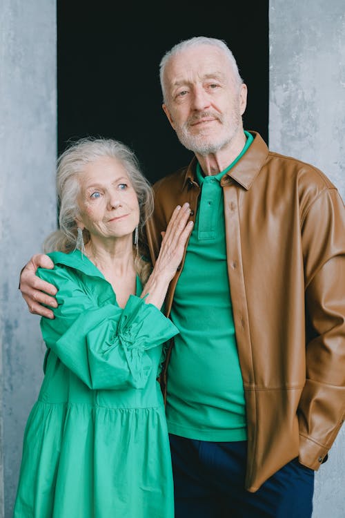 Man in Brown Coat Beside Woman in Green Dress