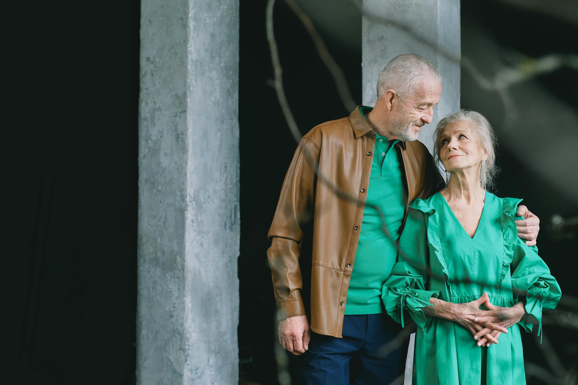 Senior couple standing affectionately together indoors, conveying love and companionship.