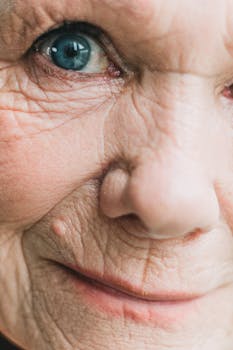 Extreme close-up of an elderly person's eye and face, emphasizing wrinkles and textures.