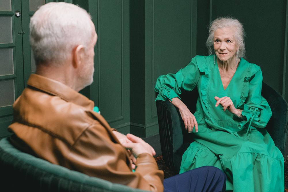 Hombre y mujer mayores conversando en un ambiente interior