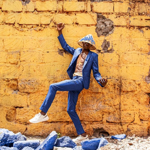 A Man in a Blue Blazer Posing Near a Yellow Wall