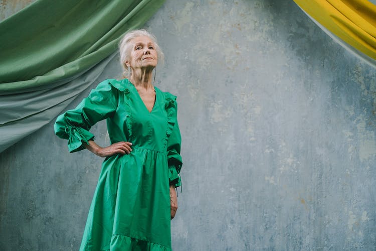 Old Woman In Dress Posing On Blue Background