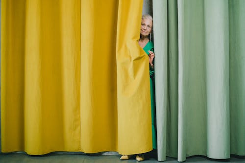 Woman Looking from behind of Curtains