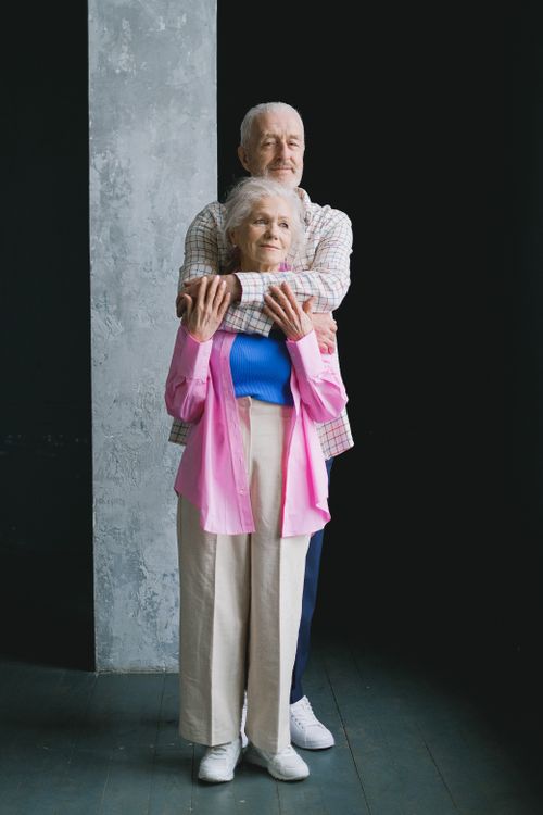 Free A heartwarming image of a senior couple embracing lovingly in a studio setting. Stock Photo