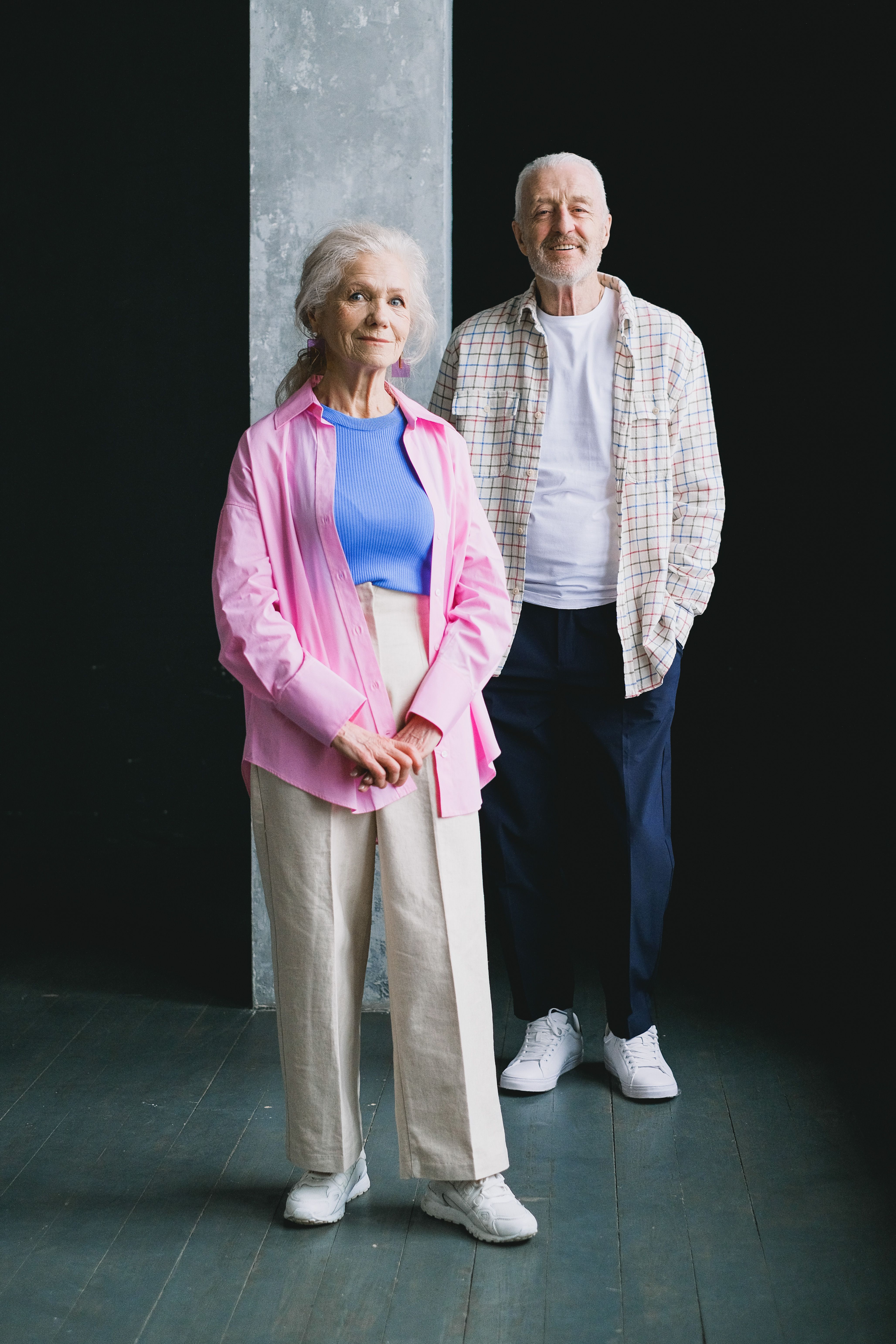 A happy senior couple posing together indoors with joyful expressions.
