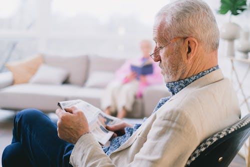 Free Selective Focus Photo of an Elderly Man Reading a Newspaper Stock Photo