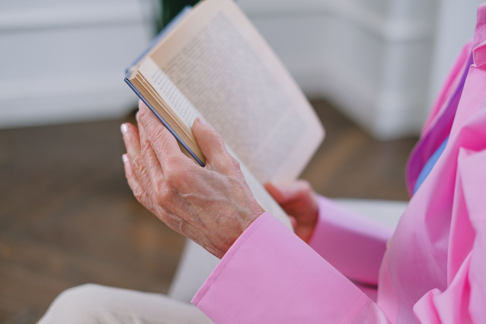 Mains d'une personne âgée tenant un livre