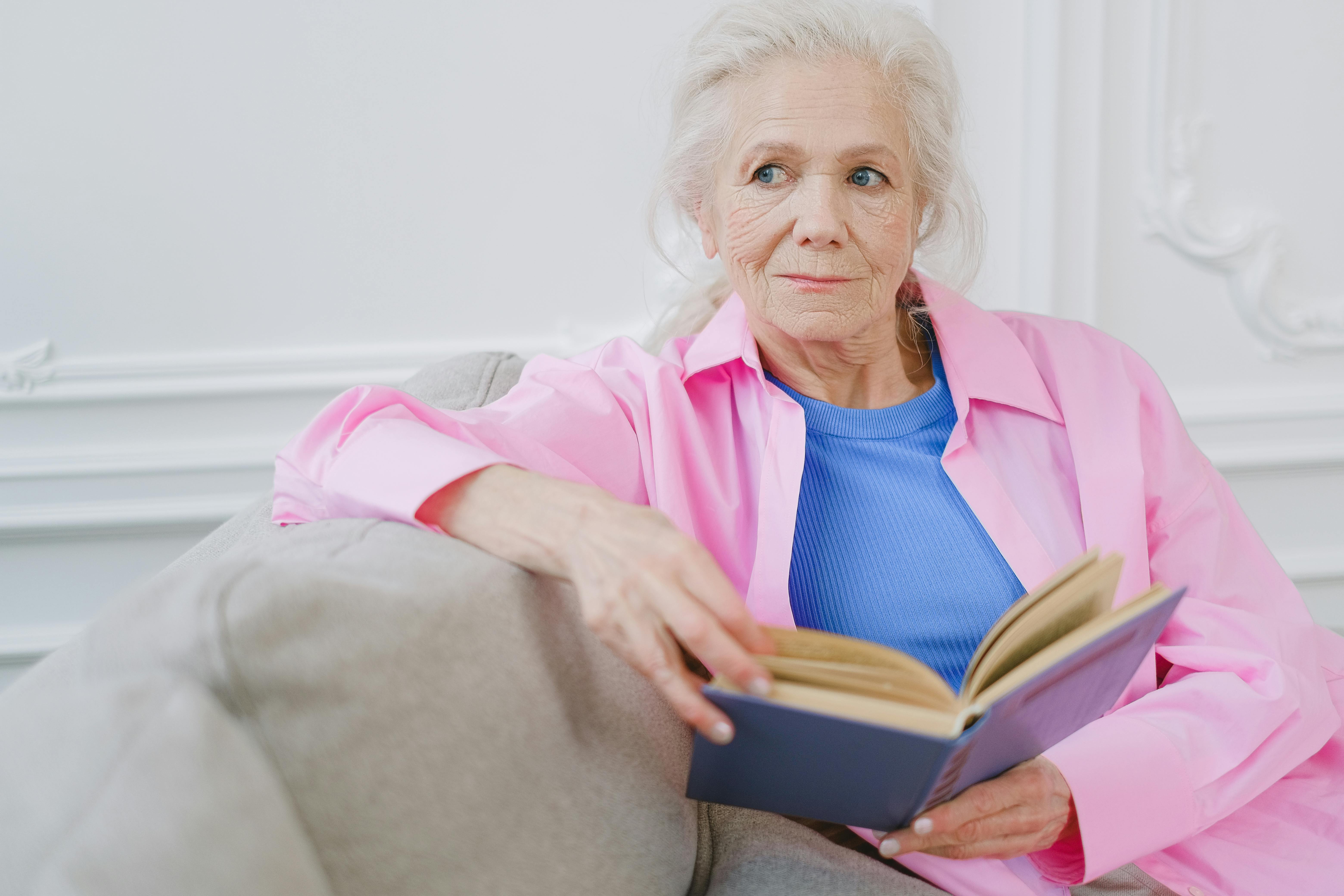 Seventies, people, old age, older woman sitting in an armchair reading a  book, full length portrait, Stock Photo, Picture And Rights Managed Image.  Pic. VIG-4306623