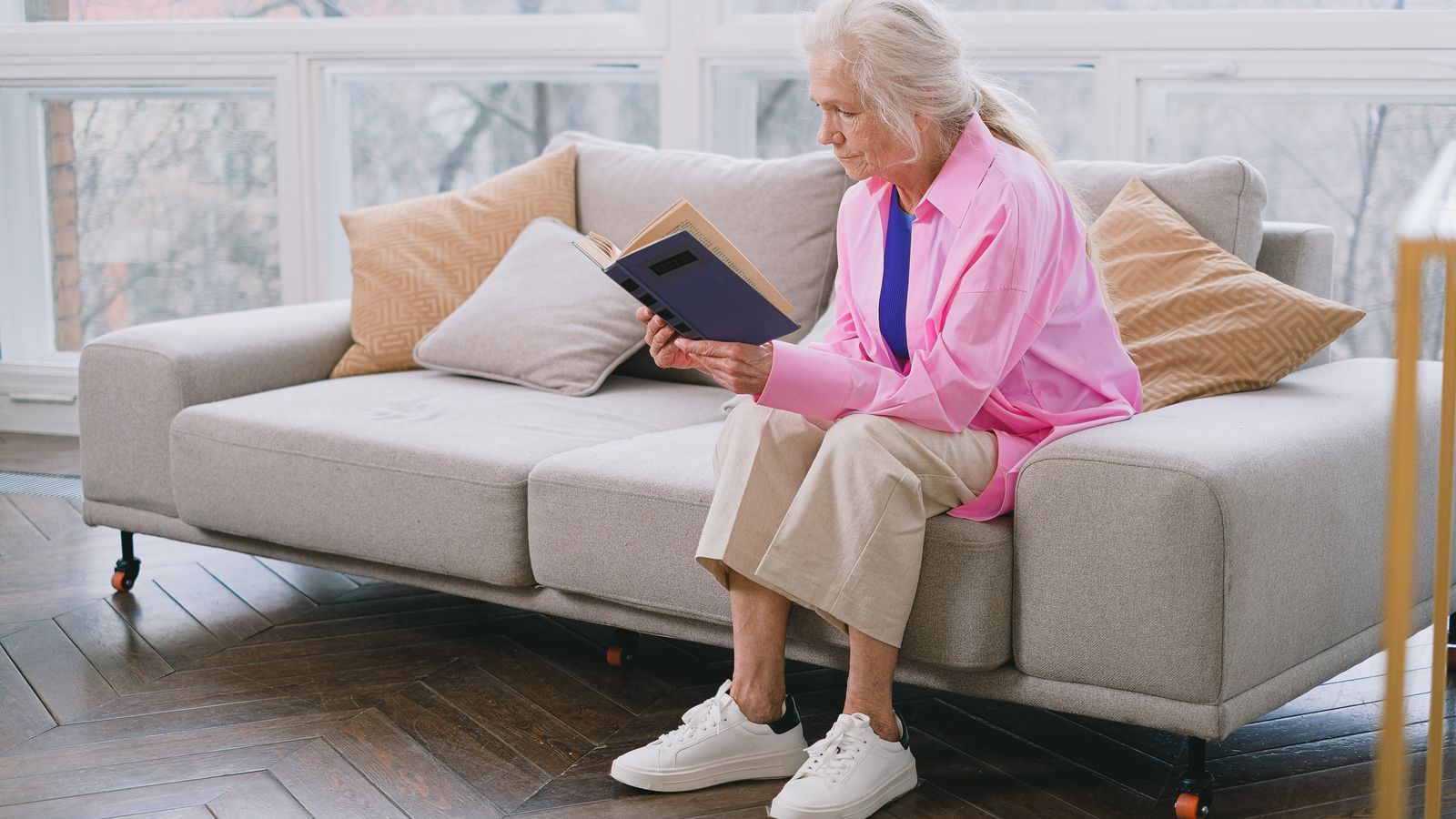 An older woman reading in a comfortable home.