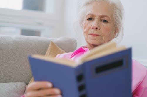 Close-Up Photo of an Elderly Woman Reading a Book
