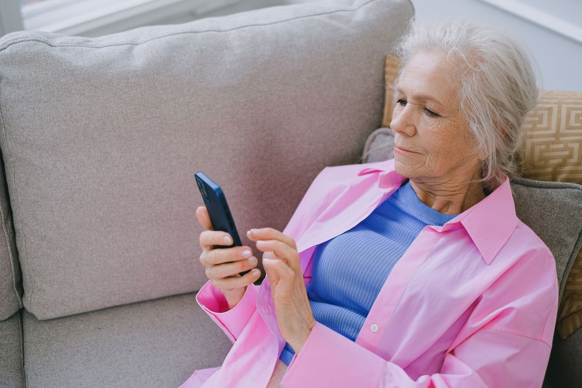 Une grand-mère lit un message sur son téléphone