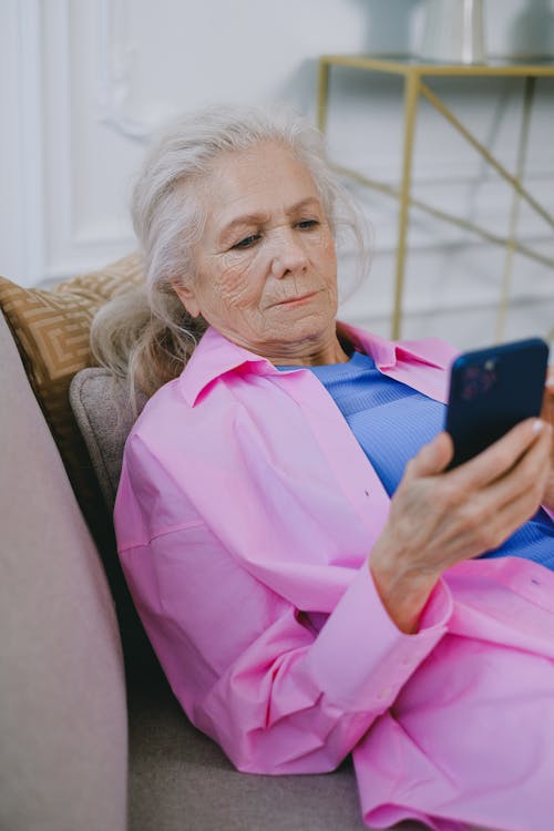Free Photo of an Elderly Woman in a Pink Shirt Using Her Cellphone Stock Photo
