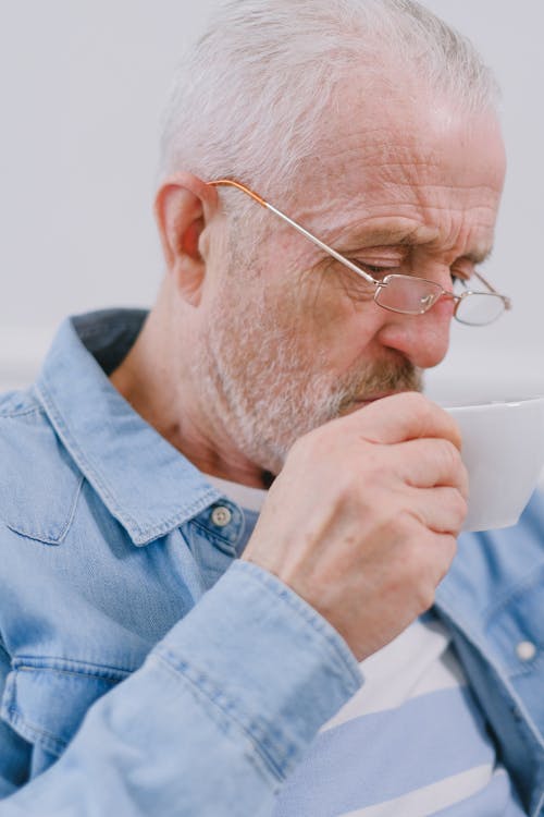 Free Portrait of an Elderly Man Drinking from a Cup Stock Photo