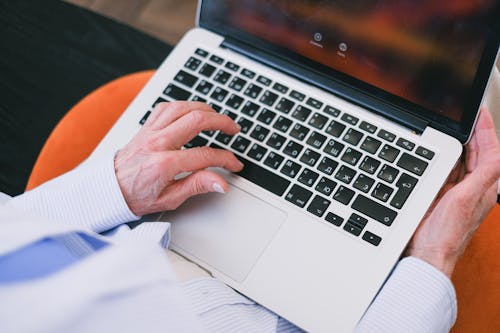 A Person's Hand Typing on a Laptop Keyboard