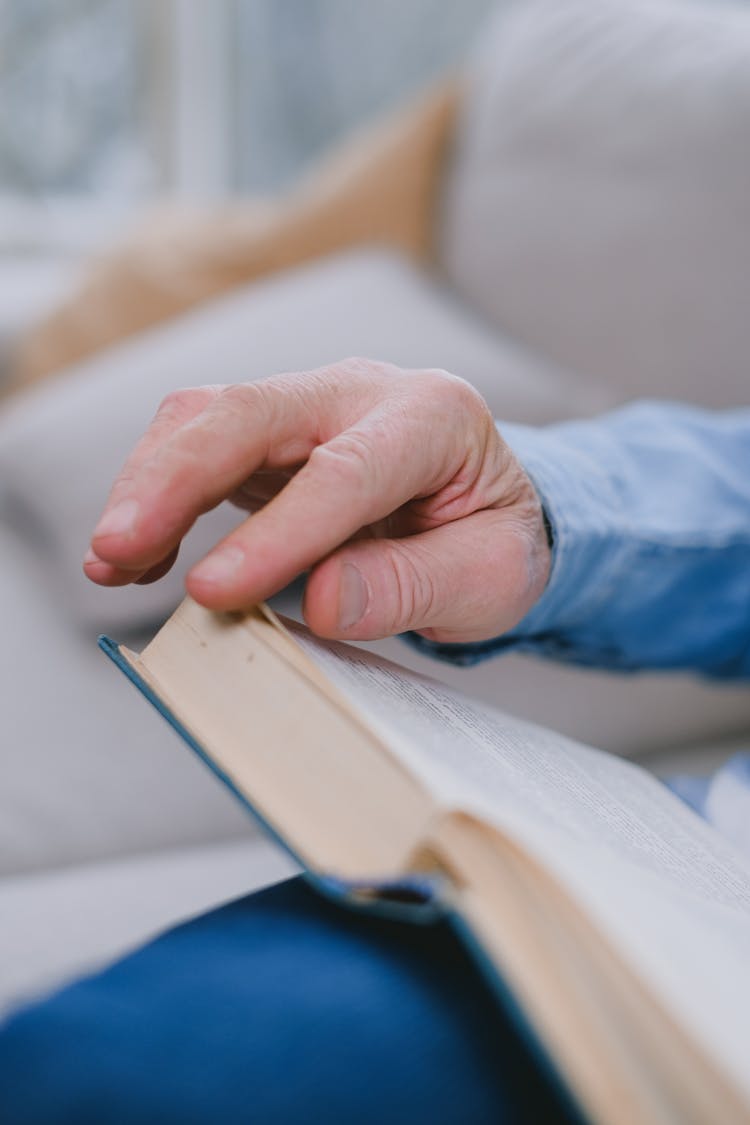 A Person's Hand Turning A Page Of A Book