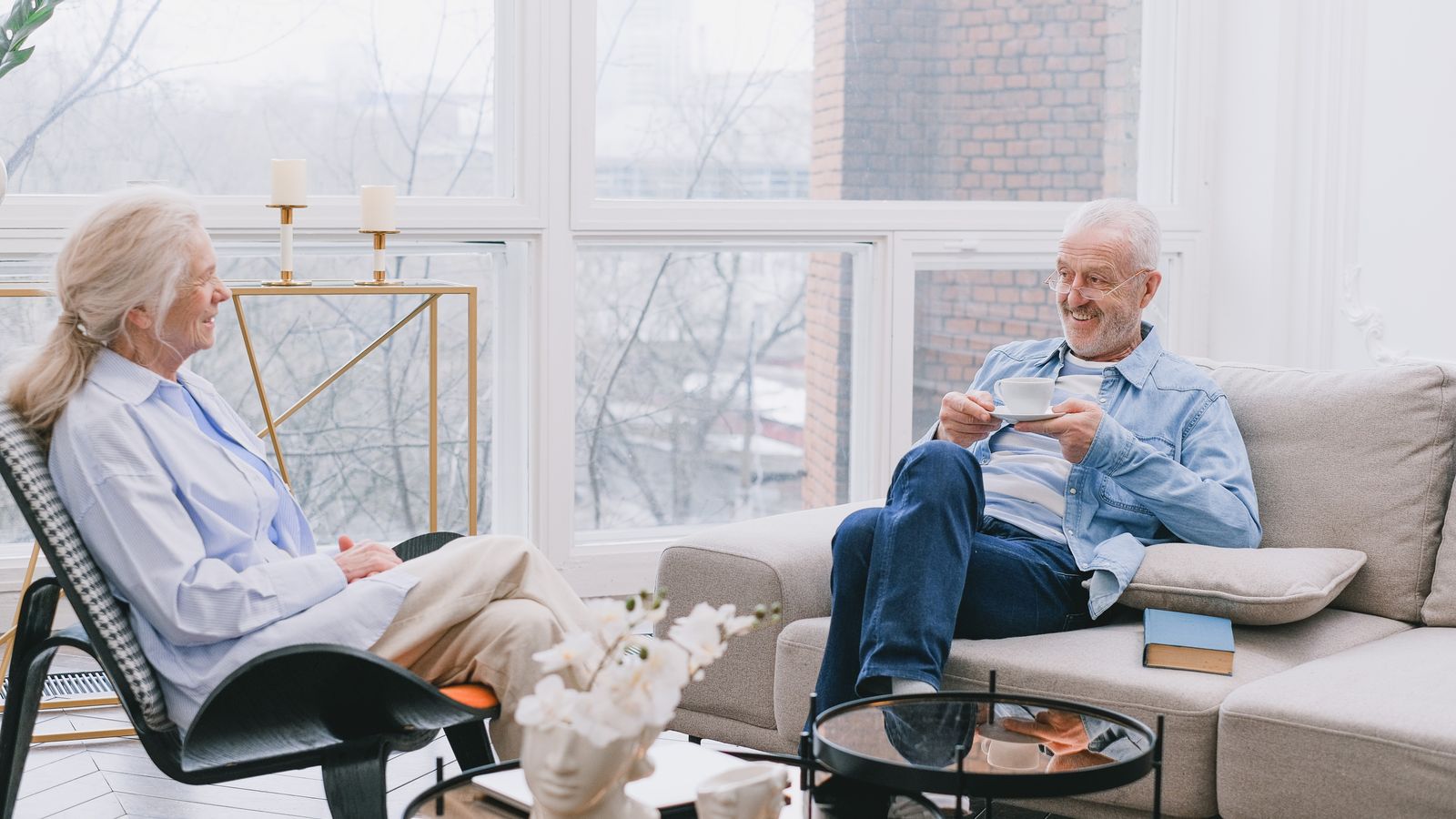 Two people talking over tea in a bright living room
