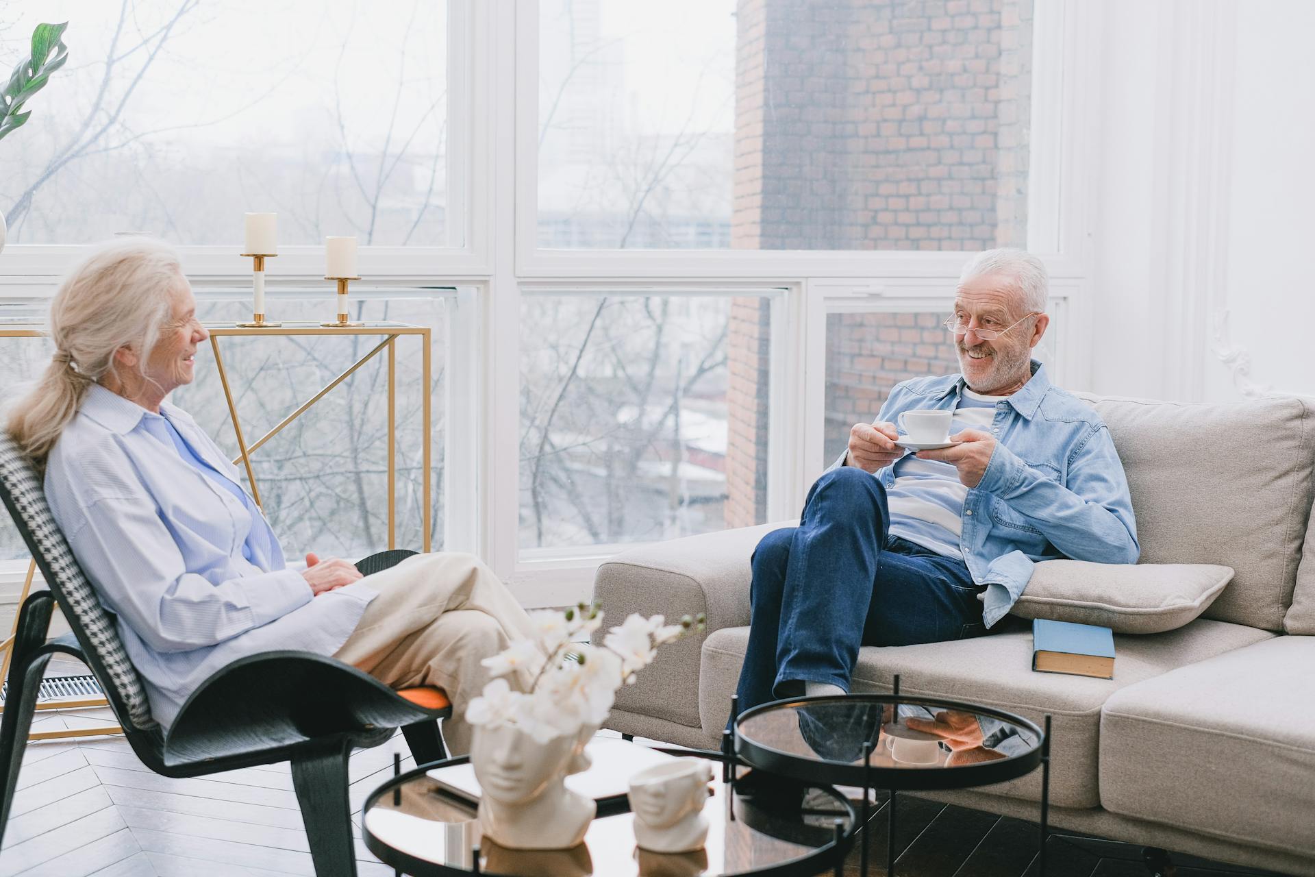 Senior couple relaxing and chatting over tea in a cozy living room.