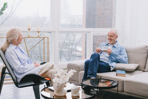 Free Senior couple relaxing and chatting over tea in a cozy living room. Stock Photo