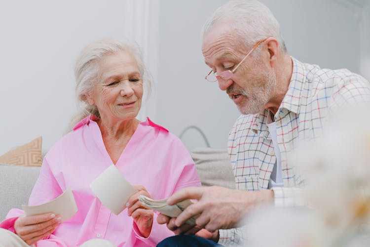 A Couple With Gray Hair Looking At Photos Together