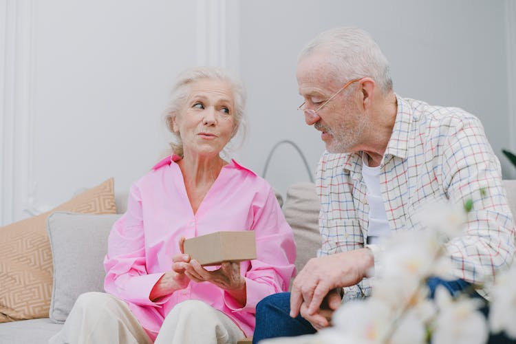 An Elderly Couple Looking At A Box Together