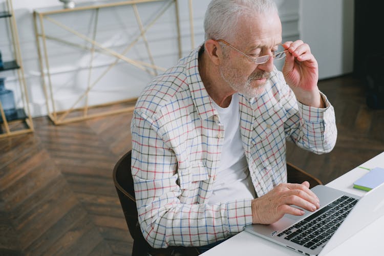 An Elderly Man Working On His Laptop