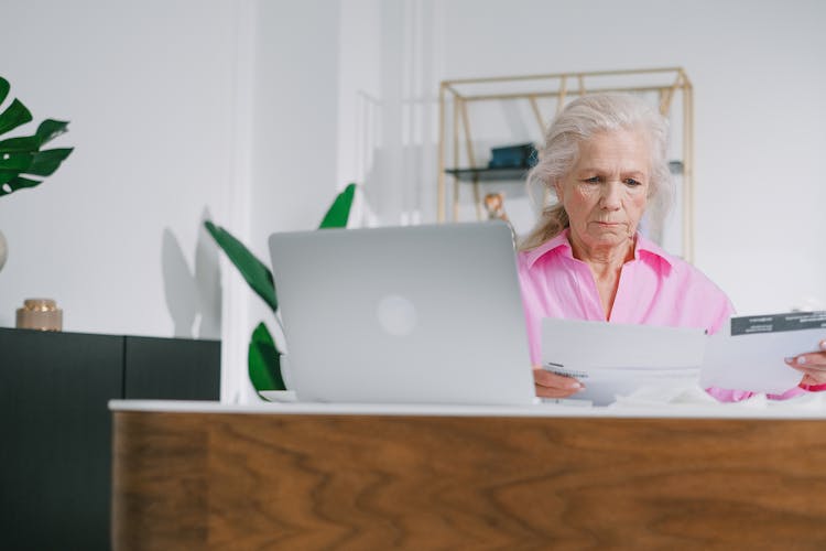 An Elderly Woman Looking At The Documents