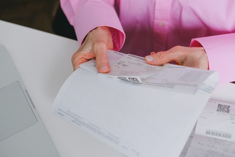 A person organizing paper receipts and documents on a desk